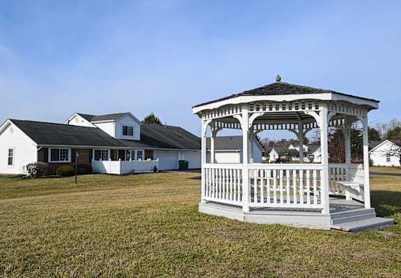 a gazebo with a house in the background