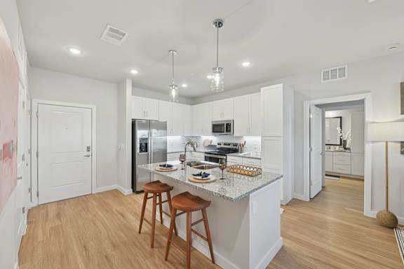 A kitchen with a white countertop and wooden floors.at Allegra at Cocoa in Cocoa, FL, 32926