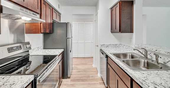 a kitchen with granite counter tops and stainless steel appliances