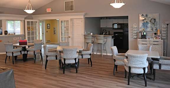 A dining room with a table and chairs.