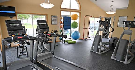 A gym with treadmills, exercise bikes, and other equipment.