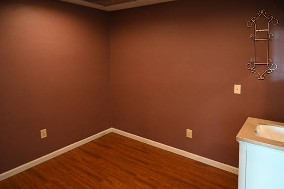 A bathroom with brown walls and a white sink.