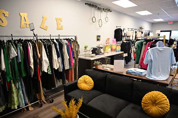 A clothing store with a sale sign on the wall.