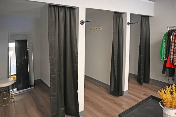 A room with a grey curtain and a black table.