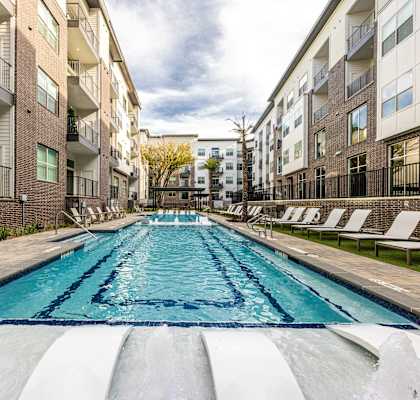 an apartment swimming pool between two apartment buildings at The Monroe Apartments, Austin, 78741