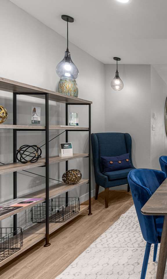 A dining room with a wooden table surrounded by blue chairs.