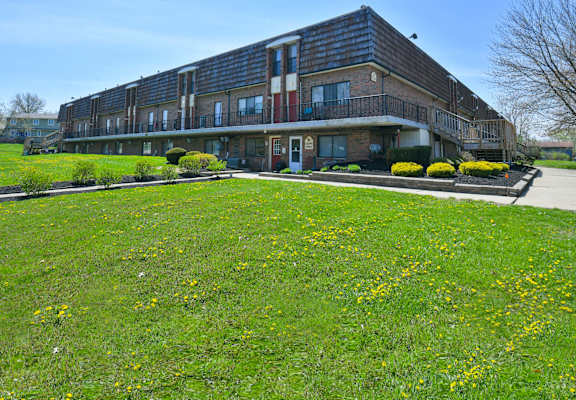 a large building with a green lawn in front of it