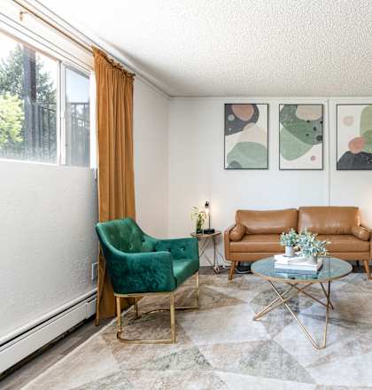 a living room with two green chairs and a brown couch