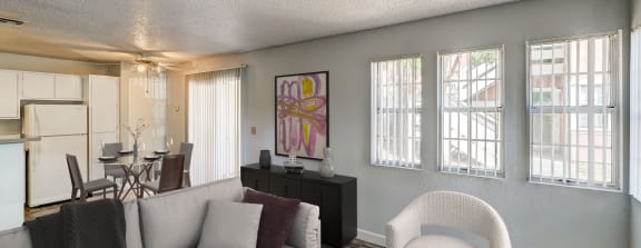 an open living room and kitchen with a table and chairs and a refrigerator