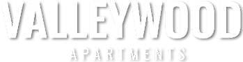 A black and white image of a sign for Valleywood Apartments.