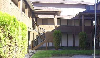 Apartment complex with a green lawn in front.