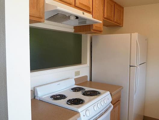 a white stove top oven sitting next to a refrigerator