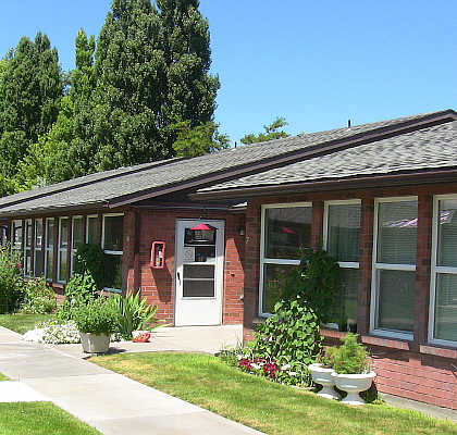 A red brick building with a white door and windows.
