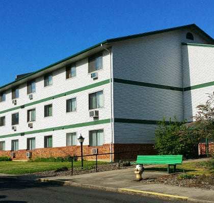 A white building with green trim and a flag on the front.