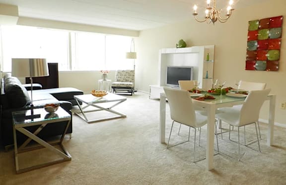 A living room with a white dining table and chairs.