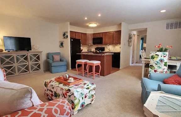 A living room with a couch, chair, and a television.