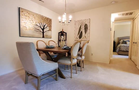 A dining room with a table set for four.