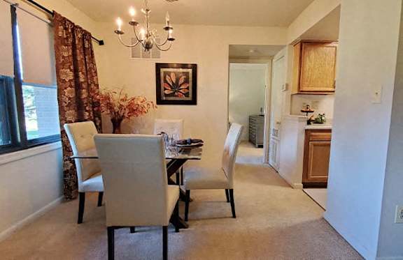 A dining room with a table and chairs.