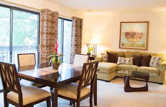 A dining room with a table and chairs.