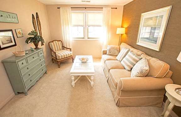 A living room with a sofa, armchair, and coffee table.