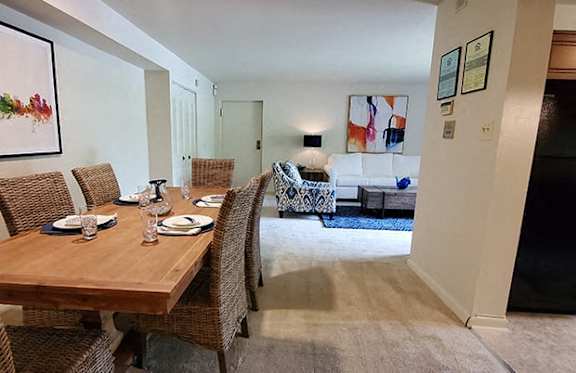 A dining room with a wooden table and chairs.