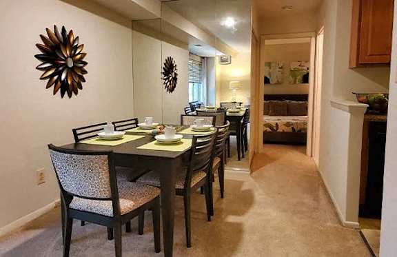 A dining room with a table set for four.