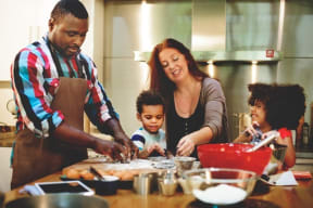 a family in a kitchen preparing food together at Sage Creek Apartment Homes, Simi Valley
