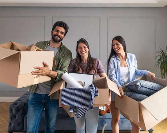 a group of people holding boxes in a living room