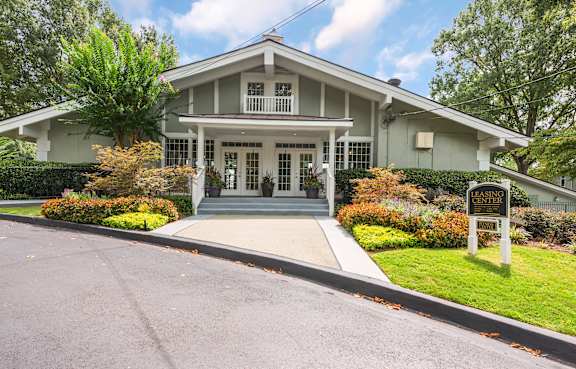 A house with a sign that says "For Sale" in front of it.