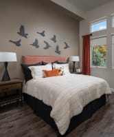 a bedroom with a bed and birds on the wall