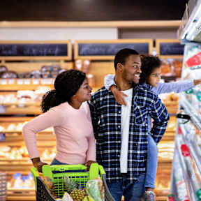 A man and a woman are shopping together in a grocery store.