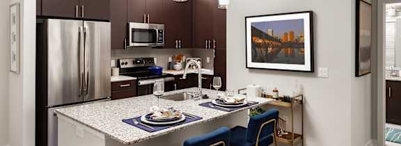 A kitchen with a table and chairs and a fridge.