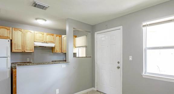 an empty kitchen with a door to the living room