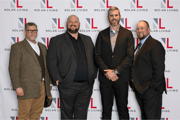 a group of men posing for a photo on a red carpet