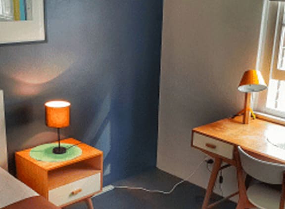 a small room with a desk and a chair and a lamp