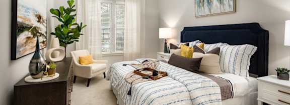 A bedroom with a large bed and a painting on the wall.