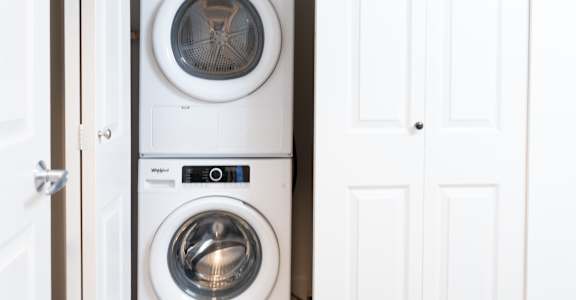 Two white front load washing machines in a white door.