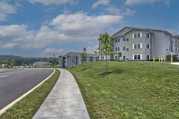a sidewalk running next to a row of apartment buildings