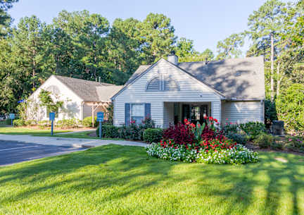 A large outdoor swimming pool surrounded by trees and lounge chairs. at Woodwinds, South Carolina, 29803