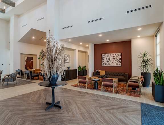A large room with a wooden floor and a variety of seating options.