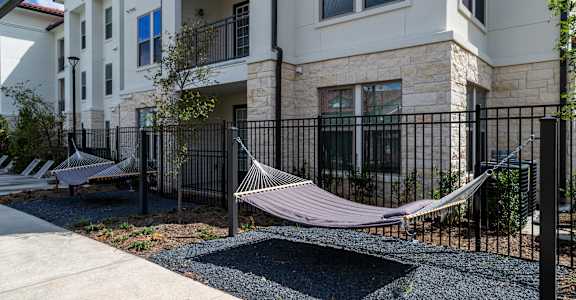 A hammock is strung between two balconies of a multi-story apartment building.