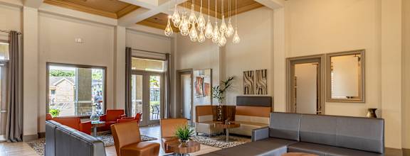 Common room with large couch and fancy lights at Grand Villas at Cinco Ranch, Katy, Texas