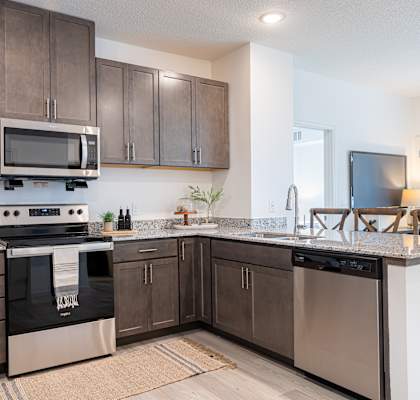 an open kitchen with stainless steel appliances and granite counter tops