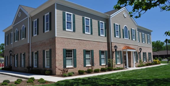 A two-story building with a mix of brick and siding exterior.