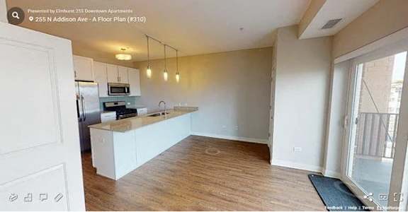 A kitchen with white cabinets and a wooden floor.