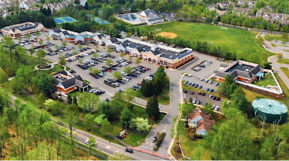 A parking lot with several cars and a building in the background.