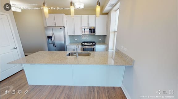 A kitchen with a granite countertop and stainless steel appliances.