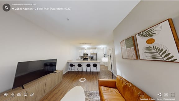 A living room with a brown leather couch and a television.