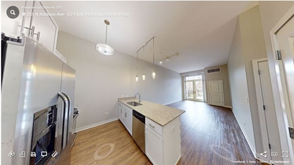 A kitchen with a refrigerator, sink, and cabinets.