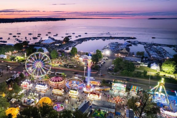 an aerial view of a ferris wheel at a carnival at dusk
